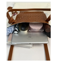 Vertical top view showing large brown shoulder bag capacity with iPad and cosmetics