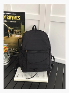 Detailed view of lightweight black nylon backpack with decorative elastic bungee cords