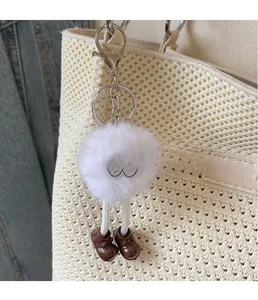 Détail du porte-clés monstre en peluche blanche avec petites chaussures brunes