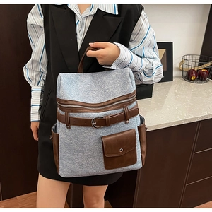 Detail of light blue vintage backpack featuring leather straps and side storage pockets