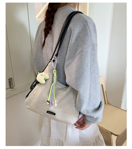 Detail of MUONJIN canvas tote bag with side zipper and cute plush moon charm accessory