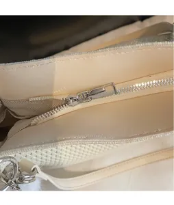 Vue macro d'une fermeture éclair en métal argenté sur un sac de plage beige texturé