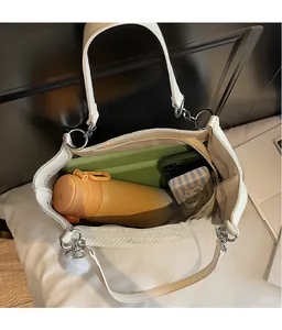 Vue détaillée de l'intérieur spacieux d'un grand sac fourre-tout en maille beige