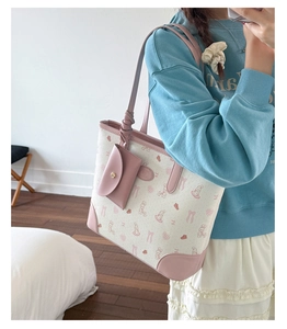 Detail of cute tote bag with pink rabbit print and small matching coin purse attachment