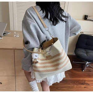 Détail du sac cabas en maille rayée avec bandoulière cuir chaîne et pompon