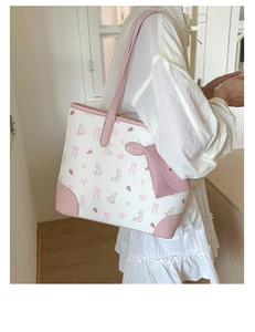 Detail of printed tote bag with pink trim featuring Sweet Day rabbit patterns and mini pouch