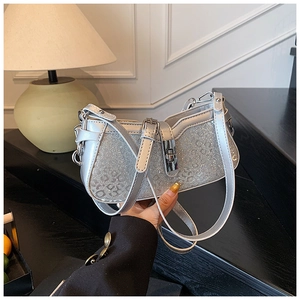 Close-up of a silver sequined handbag with a metallic twist lock and chic waved top edge