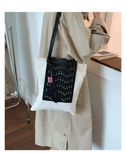 Detail of hollow wave pattern on white canvas bucket bag with star charms