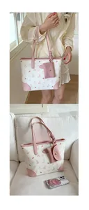 Detail of white tote bag with pink rabbit patterns and matching mini coin purse accessory