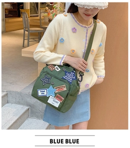 Detail der armeegrünen Segeltuchtasche mit Vintage-Patches und Sternstickerei