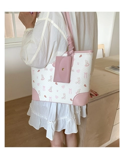 Close-up of pink rabbit print tote bag with attached mini flap pouch and golden buckle