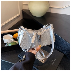 Detail of silver glitter underarm bag featuring a metallic turn-lock and adjustable strap