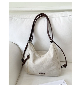 Detail of canvas tote bag with brown straps and functional vertical side zipper pocket