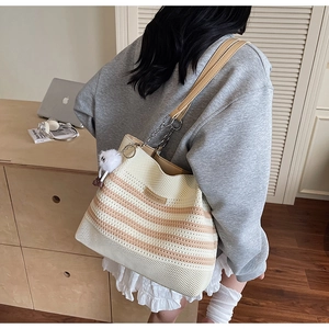 Détail du grand sac cabas en tricot rayé avec bandoulière chaîne et breloque peluche