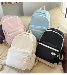 Flat lay of colorful nylon backpacks in pink, blue, beige and black for casual travel use
