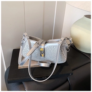 Detailed close-up of silver sequin shoulder bag with metallic lock and D-pattern texture