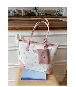 Detail of pink floral canvas tote bag with leather handles and a matching mini pouch