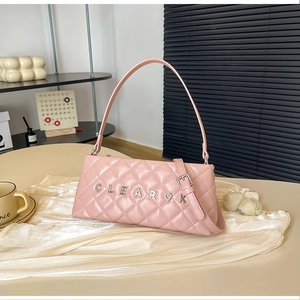 Detail of pink quilted baguette bag featuring a crystal-encrusted metal letter ornament