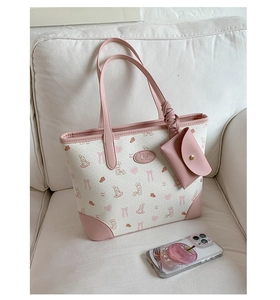 Detail of pink and white tote bag with rabbit print and mini snap coin purse on strap
