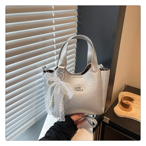 Detail of silver textured bucket bag with lace pearl bow charm and embossed logo