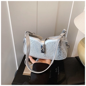 Close-up of sparkling silver sequin handbag with metallic clasp and fine strap detail