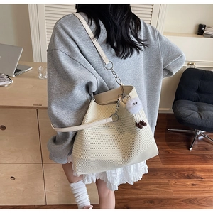 Détail d'un sac cabas en maille beige avec texture ajourée et un joli pendentif peluche