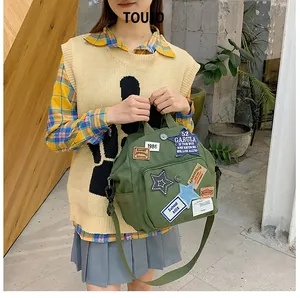 Detailansicht des olivgrünen Canvas-Rucksacks mit Stern-Patches und verstellbaren Trägern