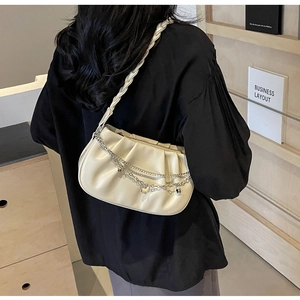 Détail du sac carré plissé avec chaînes à cœur argentées et bandoulière tressée