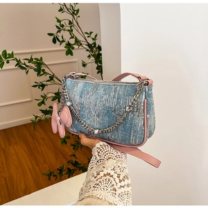 Detail of blue sequin denim bag with crystal chain and pink leather ribbon charm