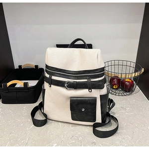 Detail of off-white lychee texture faux leather backpack with black buckle straps