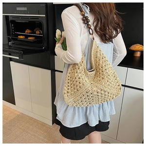 Detail of woven straw tote bag with brown wooden bead shoulder strap and floral crochet design