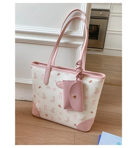 Detail of printed canvas tote with pink leather trim and cartoon rabbit pattern