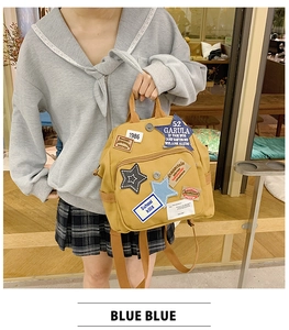 Detail des gelben Canvas-Rucksacks mit Vintage-Patches, 1986-Stickerei und Seitentaschen