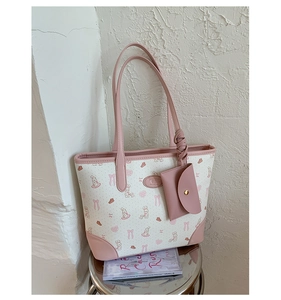Detail of printed tote bag with a matching small coin purse charm on a metal stool