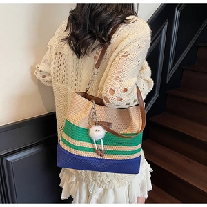 Texture tricotée détaillée du sac de plage rayé avec un joli charm pompon blanc élégant