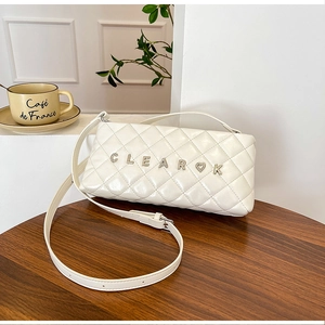 Detailed macro view of white quilted leather texture and silver CLEAR heart metal buckle