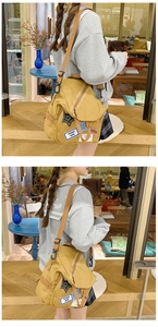 Detailansicht des gelben Canvas-Rucksacks mit Stern-Applikationen und braunen Trägern