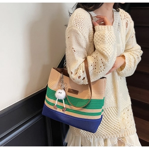 Détail du sac cabas tissé à la main avec rayures color-block et accessoire de poupée