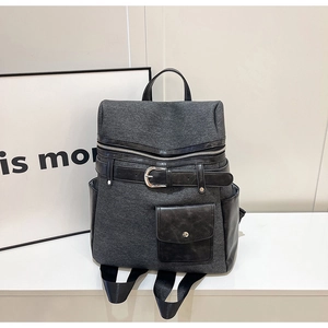 Detail of grey fabric and black leather stitching on a stylish backpack with buckle
