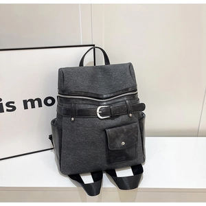 Detailed side view of vintage grey tweed backpack with black leather trims and metallic buckles