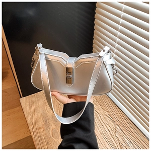 Detail of silver metallic handbag with unique wavy opening and square twist lock closure