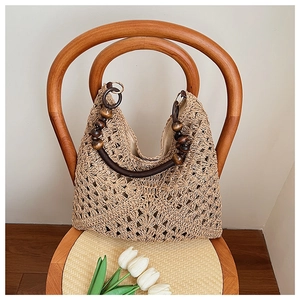 Detail of bohemian woven tote bag with wooden ring handle and bead accents on chair