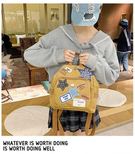 Nahaufnahme des gelben Canvas-Rucksacks mit Vintage-Patches und verstellbaren Trägern