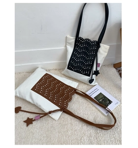 Detail of canvas bucket bags with laser-cut leather hollow patterns and star charms