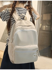 Detail view of cream white nylon backpack showing side pocket and hello DAPING brand tag
