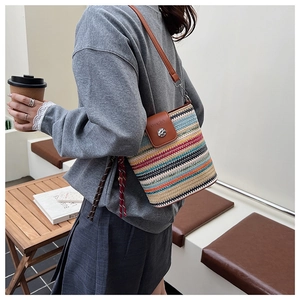 Détail du sac seau tissé coloré avec bandoulière en cuir et boucle en métal argenté