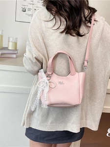 Pink lychee texture bucket bag with pearl charm shown on a model for casual daily style