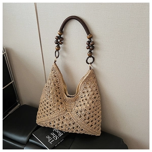 Detailed view of summer straw tote bag with geometric weave and wooden bead handle