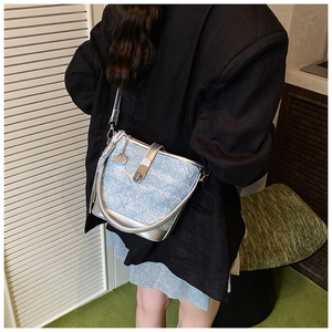 Dettaglio borsa a secchiello in denim azzurro plissettato con finiture argento e cuore