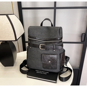 Detail of dark grey textured backpack with leather trim and magnetic buckle pocket